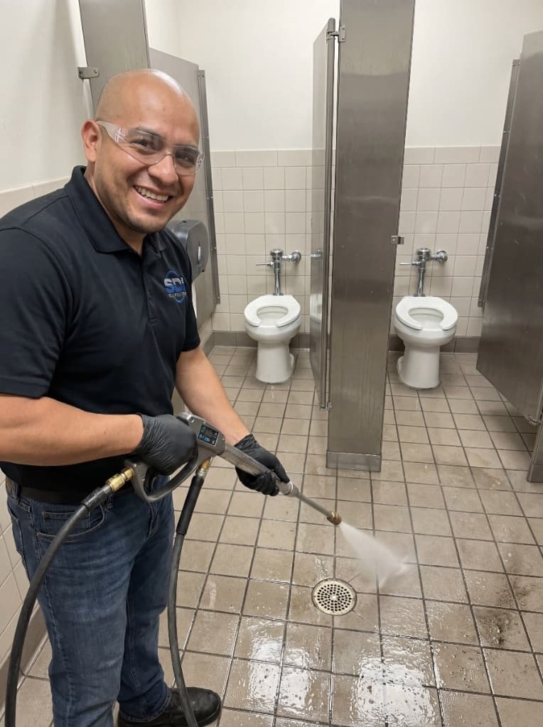 SDI technician detail cleaning commercial restroom fixtures and grout
